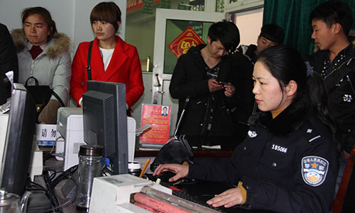 图4为王玮在为群众办理户籍业务。